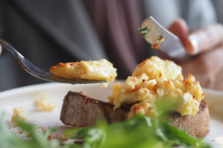 morning breakfast with Scrambled eggs on a bread on white plateの写真素材