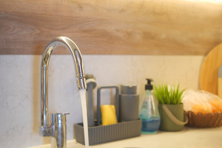 water pouring from a faucet tap slow motionの写真素材