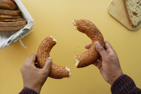 top view of hand cracking Turkish Bagel Simit