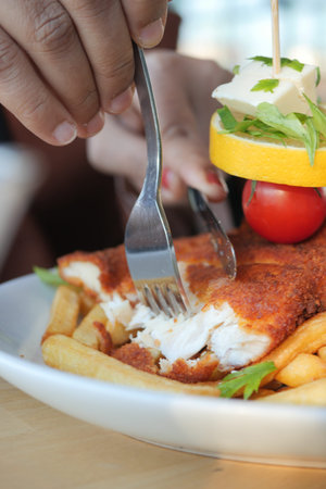 women eating Chicken schnitzel served with potato chips