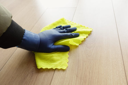 A mans hand washing the floor with a cloth