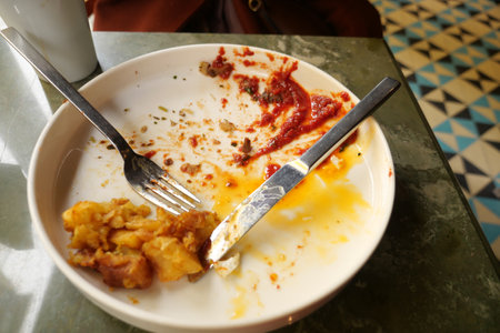 An empty dirty plate with a fork.の写真素材