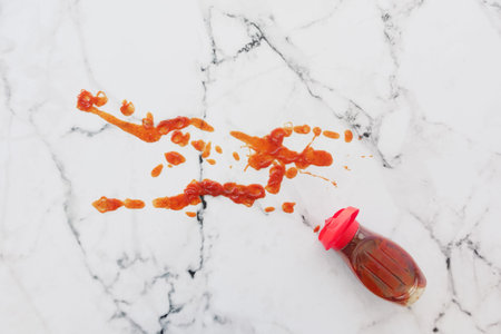 red ketchup splashes on tiles background, tomato puree texture.