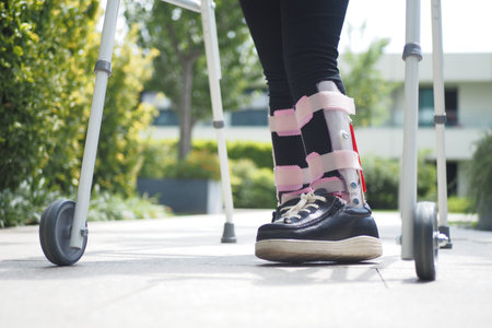 child with walking frame and knee orthosis outdoor