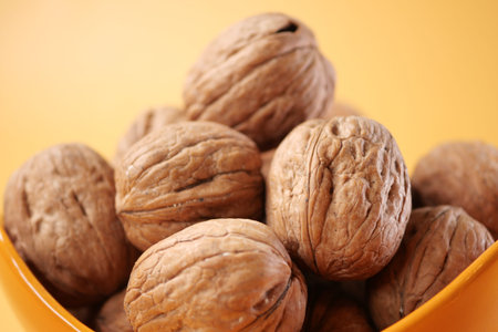 natural walnut in a bowl on yellow background