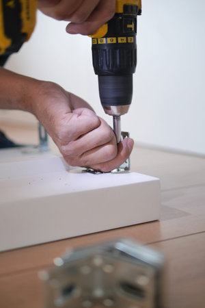 using electric drilling on white wooden board
