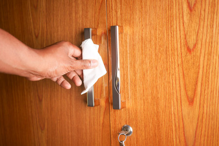 cleaning door knob with tissue close up