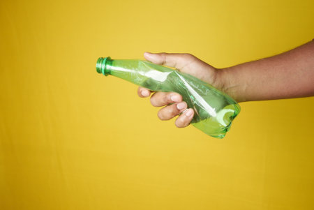 A person is grasping a plastic bottle with their fingers and thumbの写真素材