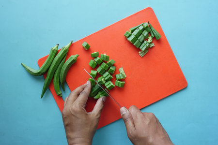 top view of ladies fingers or bhindi cutting on chopping boardの写真素材