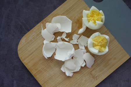 Broken egg shell on wooden cutting board,