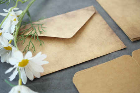 envelope , empty paper and a flower on tableの写真素材