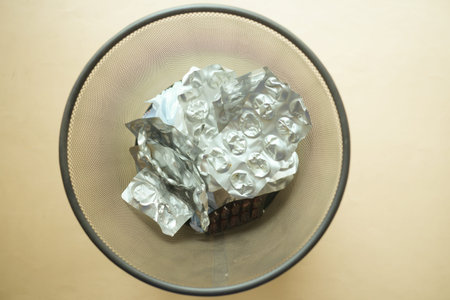 top view of pills and blister packs in a bin
