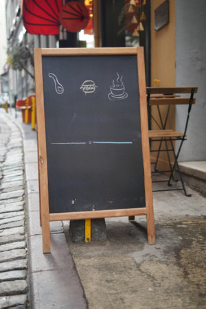 Empty wooden blackboard mockup standing outdoors in front of cafeの写真素材