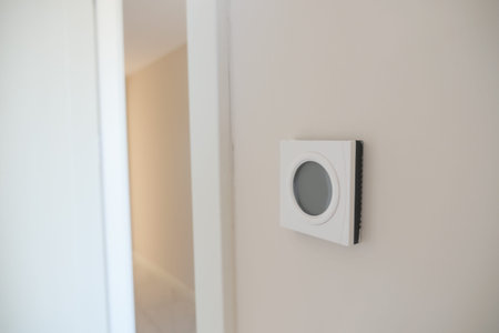 Smart Thermostat on White Wall for Optimal Home Temperature Control