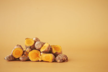 turmeric roots on a orange color background with copy space