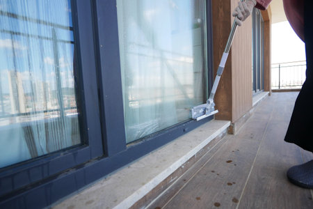 Rubber squeegee cleans a soaped window.