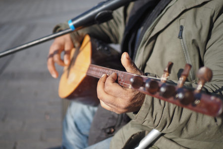 Street musician playing a string instrument in a traditional outdoor performance setting