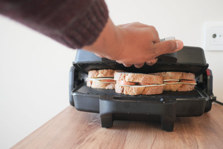Hand using finger to press button on grill gadget