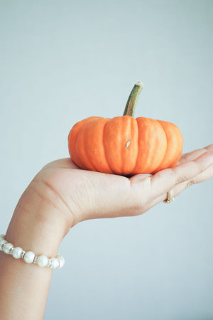 mini pumpkin on hand against white backgroundの写真素材