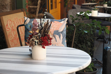 Cozy Cafe Outdoor Seating, Stylish Decor, Lush Plants, Ideal for Relaxing Al Fresco Ambianceの写真素材