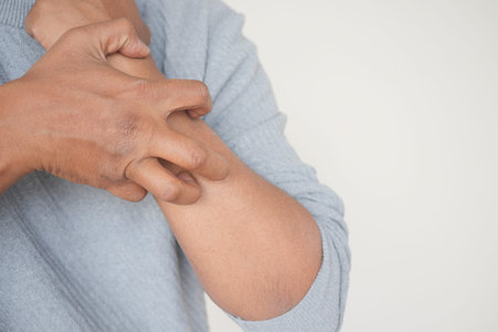 man suffering from itching skin, close up.