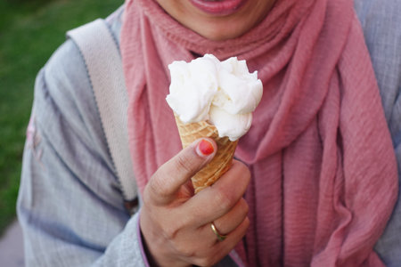 Female holds in her hand a cone with ice cream