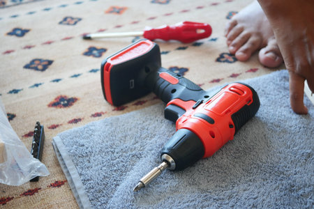 An electric screwdriver is on the floor,