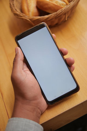 pov shot of young man hand using smart phone with white screen