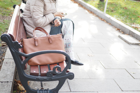 Woman left her purse on a bench in a park.の写真素材