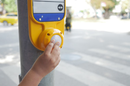 Close up of a child hand pressing the pedestrian crossing button