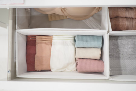 A storage basket made of wood filled with an assortment of towelsの写真素材