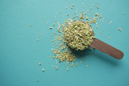 Wooden spoon with herbs on blue background representing cooking and kitchenwareの写真素材