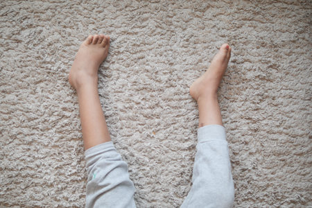 Bare feet of a child on a wooden floor represent innocence and playful moments at home