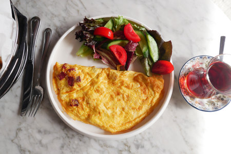 top view of Plain Egg Omelette served with salad and tea on tableの写真素材