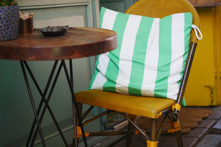 Cozy chair for outdoor cafe with striped cushion offers a welcoming and comfortable ambianceの写真素材