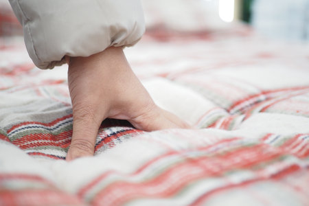 woman Hand touching and pressing orthopedic mattress on bed.の写真素材