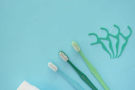 Essential Dental Care Items Featuring Toothbrushes and Flossers Set Against a Blue Backgroundの写真素材