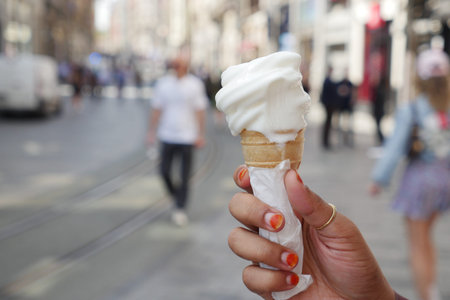 A wonderfully delicious ice cream cone enjoyed in a vibrant urban setting with charmの写真素材