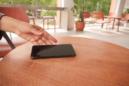 man hand picking up smart phone mobile to receive a callの写真素材