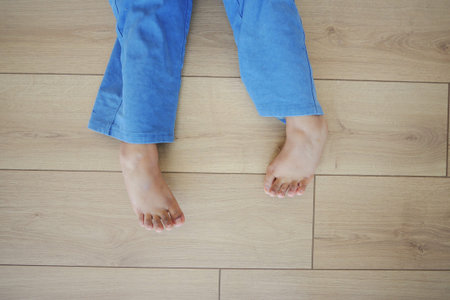 Bare feet of a child on a wooden floor represent innocence and playful moments at home