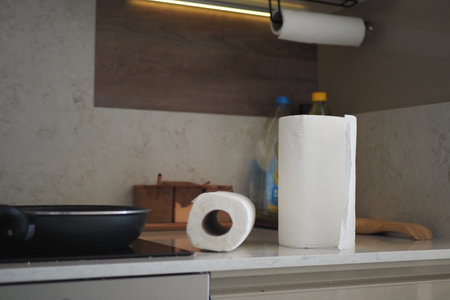 A kitchen counter featuring a paper towel roll alongside various essential cooking utensilsの写真素材
