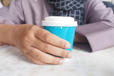 women holding a take away kraft coffee cupの写真素材