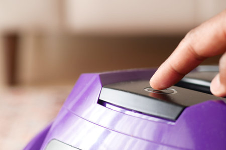 pressing start button on vacuum cleaner.の写真素材