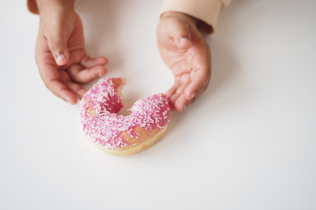 top view of child hand reaching for donutsの写真素材