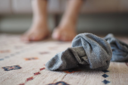 A LaidBack and Informal Home Scene Showcasing a Crumpled Sock Next to Bare Feetの写真素材