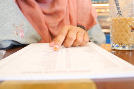 women hand reading a food menu at cafe.の写真素材