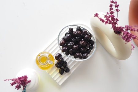 bottle of olive oil and fresh olive in a container on table .の写真素材
