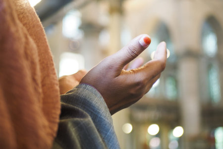 Muslim young woman in hijab is praying in mosque.