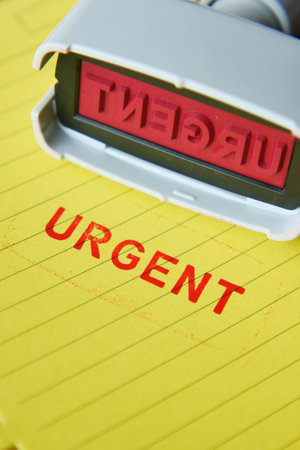 Red URGENT word stamp on a white paperの写真素材