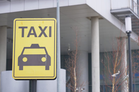Close-up photo of a yellow Taxi stand sign attached to a metal poleの写真素材